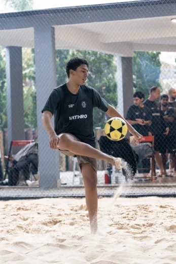 Aluno dominando a bola no futevôlei